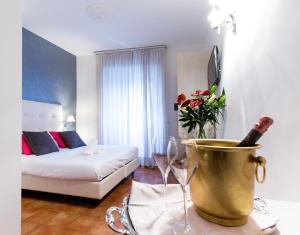 
a bed with a vase of flowers next to a table at Hotel Gabriella in Rome
