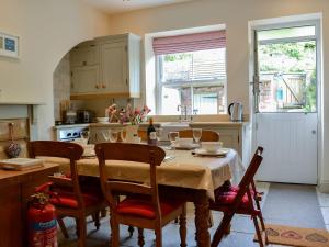 a kitchen with a table with chairs and a table and a tableablish at Norms Nook in Grassington