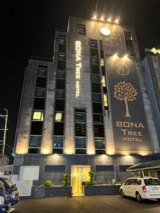 a building with a tree on the front of it at Bonatree Hotel in Busan