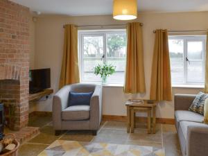 a living room with a couch and a chair and two windows at Olivia - Uk13137 in Barnby Moor
