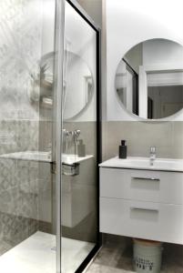 bagno con doccia, lavandino e specchio di SANTA MARÍA APARTMENT Precioso apartamento en el centro de Granada - Parking gratuito a Granada