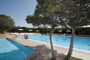 a swimming pool with people and umbrellas at Club Hotel Residence Baiaverde in Valledoria