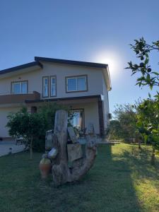 a tree stump in front of a house at Sunnyside Villa in Durrës