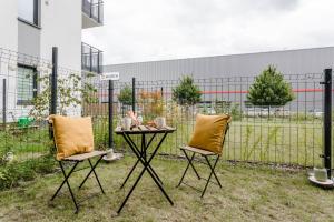 twee stoelen en een tafel in de tuin bij Enjoy! Ursus in Warschau