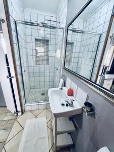 La salle de bains est pourvue d'un lavabo et d'une douche. dans l'établissement Madeira Bed, à Queenstown