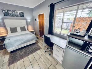 Schlafzimmer mit einem Bett, einem Schreibtisch und einem Schreibtisch in der Unterkunft Madeira Bed in Queenstown