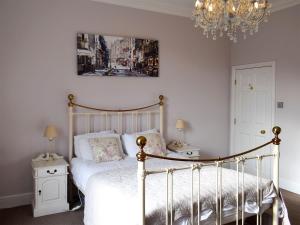 a bedroom with a bed and a chandelier at Sneaton Hall Whitby in Sneaton