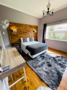 ein Schlafzimmer mit einem Bett und einer Holzwand in der Unterkunft Madeira Bed in Queenstown