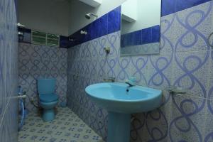 uma casa de banho com um lavatório azul e um WC. em Hotel Savonrich em Anuradhapura