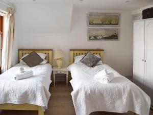 a bedroom with two beds with white sheets at Shadycombe Lodge in Salcombe