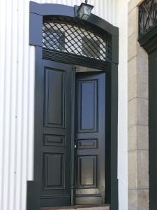 a black door on a white building with a window at Casa de Cambres in Lamego
