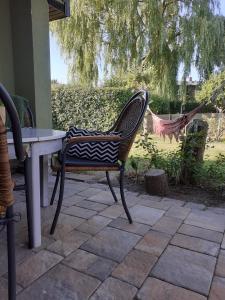 einen Stuhl neben einem Tisch auf einer Terrasse in der Unterkunft Ferienbungalow Haus Rolf - Objekt 39079 in Papendorf