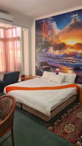 um quarto com uma cama grande e uma pintura na parede em Jerusalem Panorama Hotel em Jerusalém
