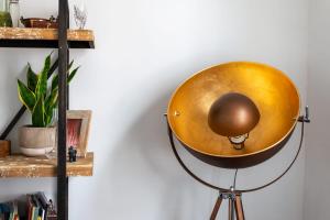 a large gold orb on a tripod in a room with a shelf at GuestReady - Modern Chic in Homerton in London