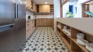 a kitchen with wooden cabinets and a tile floor at Veranera Hostel in Estepona