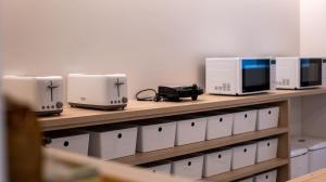 a row of microwaves and appliances on a shelf at Veranera Hostel in Estepona