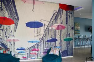 a mural of umbrellas hanging from a wall at The Red Portrait at Carlswald in Midrand