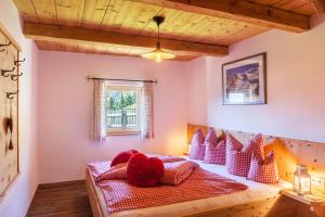 a bedroom with a bed with red pillows at Berghütte Ahornblick in Hippach