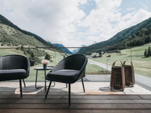 two chairs and a table on a deck with a view at VAYA Residence Galtür Paznaun in Galtür