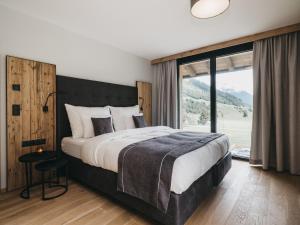 a bedroom with a large bed and a large window at VAYA Residence Galtür Paznaun in Galtür