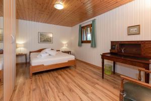 Schlafzimmer mit einem Bett und Holzboden in der Unterkunft Guesthouse La Moliere in Murist