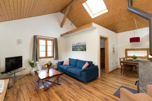 uma sala de estar com um sofá azul e uma mesa em Guesthouse La Moliere em Murist