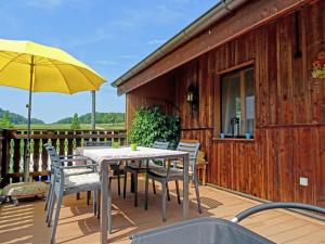 a table and chairs on a deck with a yellow umbrella at Guesthouse La Moliere in Murist