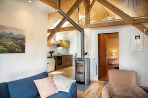 a living room with a blue couch and a kitchen at Guesthouse La Moliere in Murist