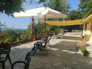 un patio con sillas y una sombrilla en Baita Sambuco en Donato