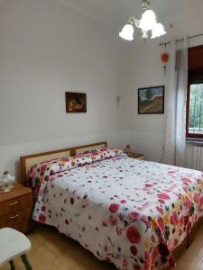 una camera con un letto e un piumone floreale di Casa Mami' a Marigliano