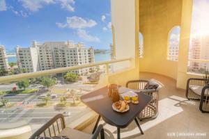 einen Tisch auf einem Balkon mit Stadtblick in der Unterkunft LUX - The Shoreline Penthouse Suite in Dubai