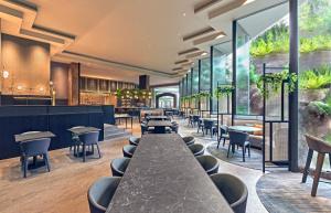 a restaurant with a long table and chairs at Vibe Hotel Singapore Orchard in Singapore