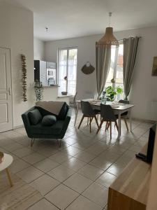 a living room with a couch and a table at Bel appartement spacieux et lumineux hyper centre Blois in Blois