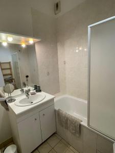 a bathroom with a sink and a tub and a shower at Bel appartement spacieux et lumineux hyper centre Blois in Blois