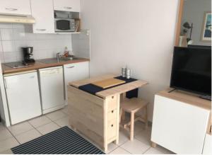 eine kleine Küche mit einem Schreibtisch und einer Mikrowelle in der Unterkunft Studio au calme avec piscine, face golf, parking gratuit, tout à pied à 10mn centre ville in Ciboure