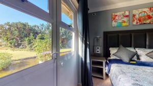 a bedroom with a bed and a large window at Caribbean Estates Lakeview Villa in Port Edward