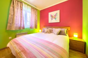 sypialnia z łóżkiem z czerwonymi i zielonymi ścianami w obiekcie Bella Vista w mieście Fužine