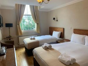 una camera d'albergo con due letti e una finestra di Beech Mount Hotel - Free Parking a Liverpool