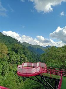 a red observation deck in the middle of a mountain at hai trái tim hồng in Bao Loc