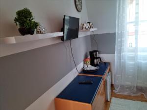 a room with a blue desk with a tv on a wall at Stral-Sund in Stralsund