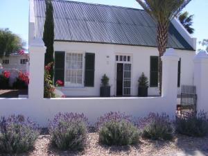 a white house with plants in front of it at Pepper Tree Accommodation in Beaufort West