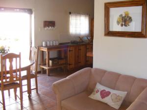 a living room with a couch and a table at Pepper Tree Accommodation in Beaufort West