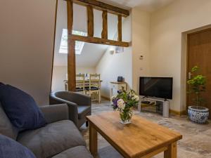 a living room with a couch and a table at Spilstead Barn in Sedlescombe