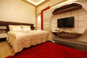 a bedroom with a bed with a television and a red rug at City Code Exclusive in Belgrade