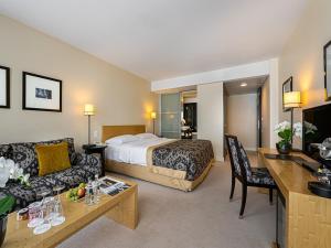 a hotel room with a bed and a couch at Jade Manotel in Geneva