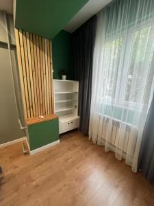 an empty room with a window and a book shelf at Evergreen Apart in Almaty