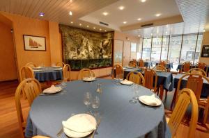a dining room with blue tables and chairs at Hôtel Restaurant l'Hirondelle in Dunkerque
