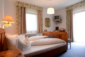 a bedroom with a large bed and a television at Frühstückspension Seerose in Weissensee +22 photos