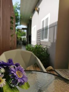 a glass table with purple flowers on top of it at De​ Lanta place in Ko Lanta