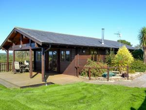 a house with a wooden deck in front of a yard at Otter - Uk12540 in Witheridge